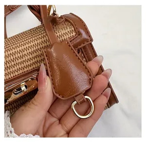 Detail of woven straw texture with brown lychee leather trim and golden metal lock