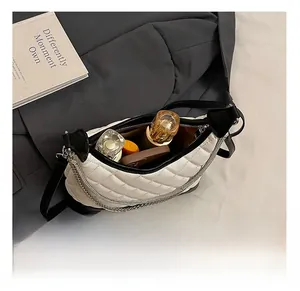 Detailed interior of a quilted crossbody bag showing storage for lipstick and perfume