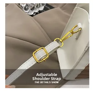 Detail of adjustable shoulder strap with golden metal buckle on white leather handbag