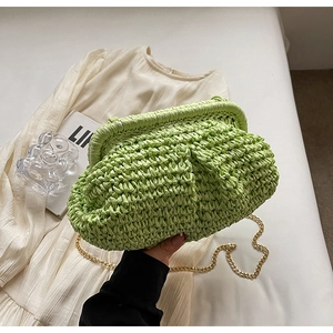 Détail d'une pochette nuage tissée vert vif avec une bandoulière en chaîne dorée chic