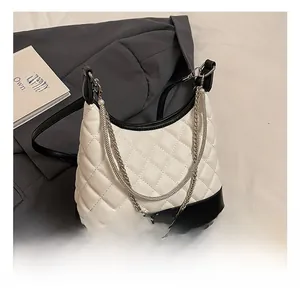 Detail of quilted leather bag with black contrast base and pearl chain strap