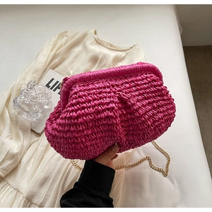 Détail du sac tressé rose en forme de nuage avec élégante chaîne dorée porté par mannequin