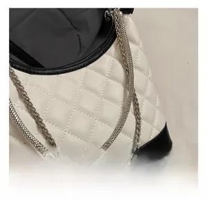 Detail of contrast quilting on leather bag with multi-layer silver metal chain straps