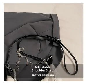Detail of adjustable leather strap and silver chain on quilted crossbody handbag