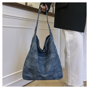 Close-up of vintage blue denim tote bag with white spot patterns and long shoulder strap