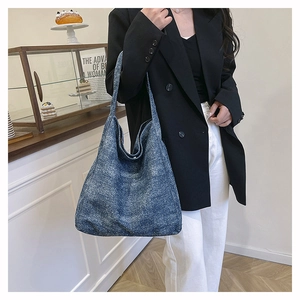 Detail of blue textured tweed tote bag with spacious design and natural draped silhouette