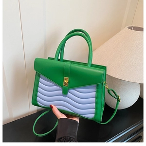 Detail of green handbag with purple wavy stitching and vintage gold clasp