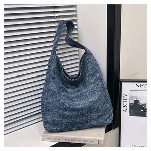 Minimalist blue denim hobo bag featuring high-texture fabric in a cozy lifestyle setting