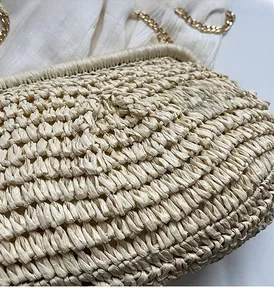 Détail de la texture du sac en paille tressé avec bandoulière chaîne dorée