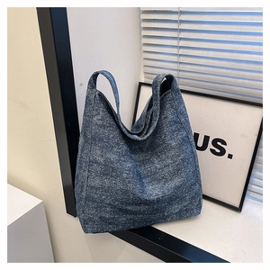 Detail of blue denim tote bag with snowflake pattern and wide shoulder strap