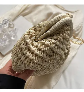 Détail du sac bandoulière en paille tressée beige avec chaîne dorée et fermoir