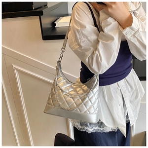 Detail of silver quilted hobo bag featuring metallic finish and decorative chain strap