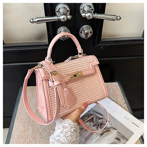 Detail of pink woven texture and leather trim on a classic mini trapezoid handbag