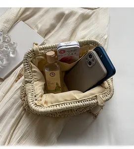 Vue de l'intérieur du sac en paille tressée montrant sa capacité pour smartphones