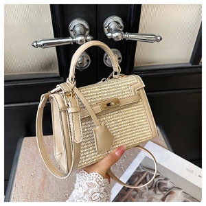 Detailed view of beige woven straw Kelly bag with smooth leather trim and gold lock hardware