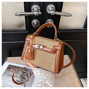 Detail of a brown leather and beige woven Kelly bag with silver metal swivel lock