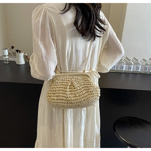 Détail du sac bandoulière en paille tissée main beige avec chaîne et fermoir vintage
