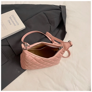 Internal view of pink quilted handbag showing yellow fabric lining and inner pocket