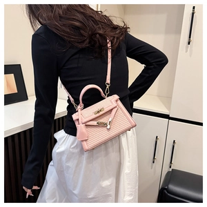 Detailed view of the pink woven texture and metallic lock on the stylish crossbody bag