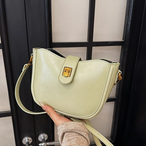 Minimalistische pistaziengrüne Eimertasche aus Leder mit goldenen Beschlägen