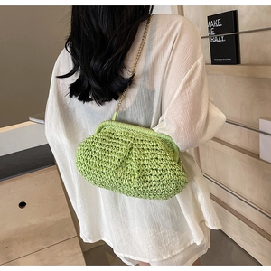Vue détaillée du sac nuage tressé vert clair avec bandoulière chaîne dorée à l'épaule