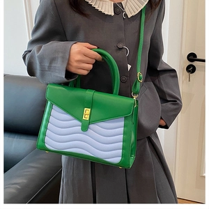 Detailed view of crocodile pattern crossbody bag featuring wavy quilting and gold turn-lock