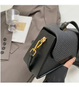 Detail of high-quality golden metal swivel hook and textured fabric of the shoulder bag