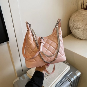 Pink quilted hobo shoulder bag with silver chain detail in a lifestyle setting