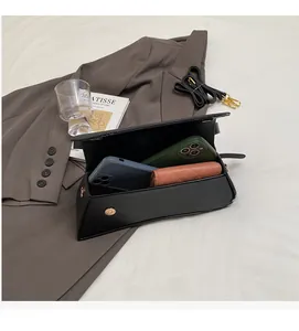 Detail view of the spacious inner compartment of the black leather crossbody square bag