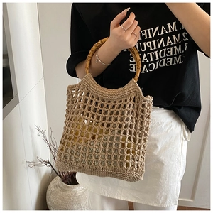 Detailed close-up of the vintage hollow knit beach bag with a natural bamboo round handle