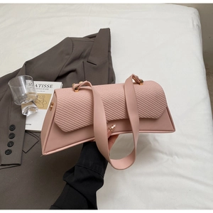 Detailed view of pink woven patchwork underarm bag on a white textured background