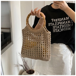 Detail of hollow knit beach bag with round bamboo handle and vintage khaki woven texture