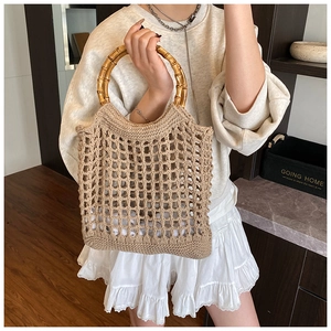 Detail of bamboo handle and beige hollow knit texture on a large capacity beach tote