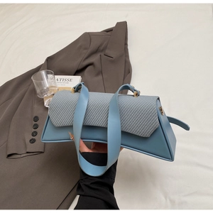 Detail of color-block flap bag with leather and woven fabric texture and gold hardware