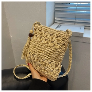 Détail du motif fleur au crochet et gland avec perles en bois sur le sac de plage