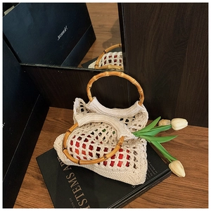 Close-up of hollow knit tote with natural bamboo handles and woven cotton texture