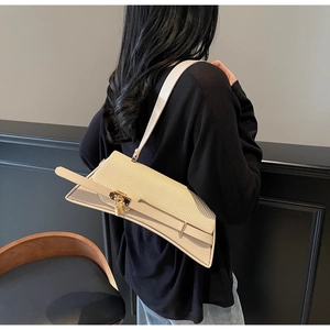 Close-up of cream woven shoulder bag with golden lock on a minimalist dark background