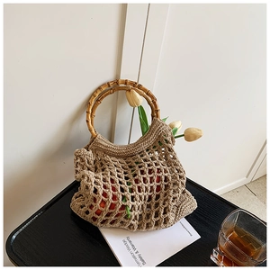 Detail of hollow knit beach bag featuring round bamboo handles and natural khaki mesh texture