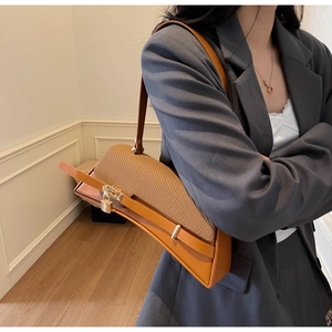 Close-up of stylish contrast color crossbody bag with leather texture and metal buckle lock