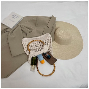 Flat lay of hollow knit beach bag with bamboo handles and summer holiday essentials