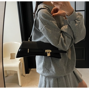 Detail of Y2K style crescent shoulder bag with mixed textures and metal buckle lock