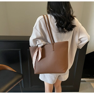 Brown litchi leather tote bag with silk scarf detail shown on model back view