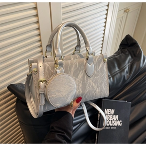 Detail of silver pleated leather tote bag with round coin purse and adjustable strap