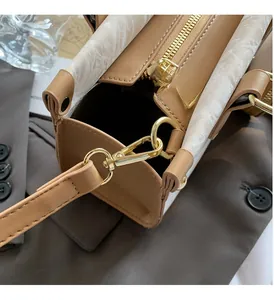 Detail of high-quality gold hardware including metal hooks and zipper on the tote bag