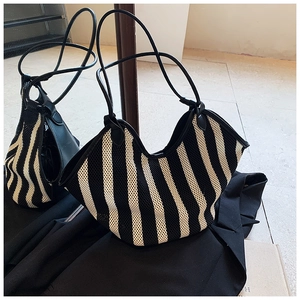 Detail of black and white zebra pattern mesh tote bag with leather texture straps