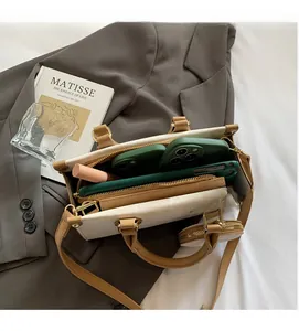 Detail of minimalist beige tote bag showing spacious interior with small round coin purse