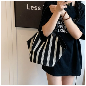 Detail of black and white striped mesh tote bag with reinforced leather handles