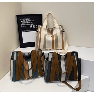 Detailed display of striped canvas tote bags in three colors with multi-pocket design