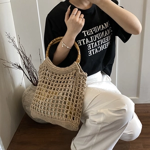 Large hollow knit beach bag with natural bamboo handles and beige bohemian weave