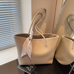 Large beige leather tote bag with elegant pink scarf detail and litchi texture finish